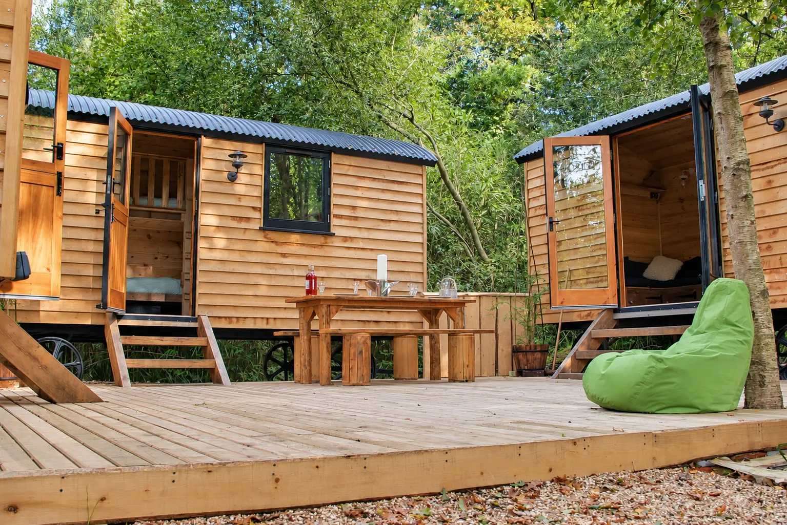 The Hideaway exterior — oak-clad shepherd huts on the decking at Into the Woods, Isle of Wight